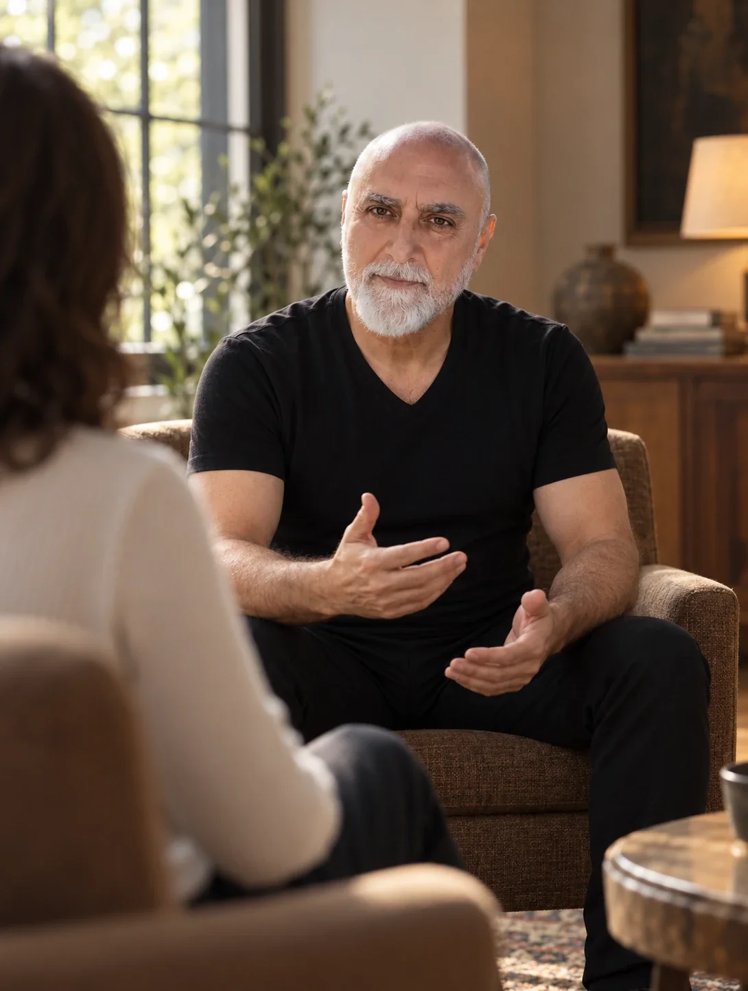 Ali in conversation with a client in a warm, quiet living room